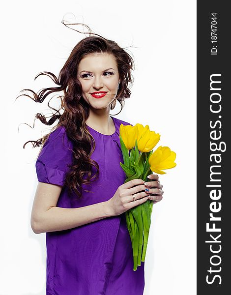 Portrait of a lovely girl with yellow tulips against white background