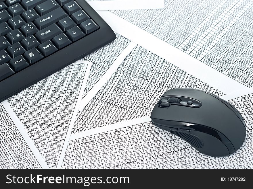 Black keyboard and mouse on a spreadsheets.