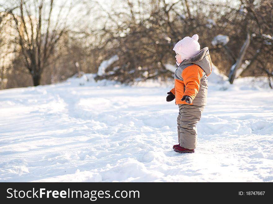 Adorable baby stay on road on hill side in winter sunny park. Adorable baby stay on road on hill side in winter sunny park