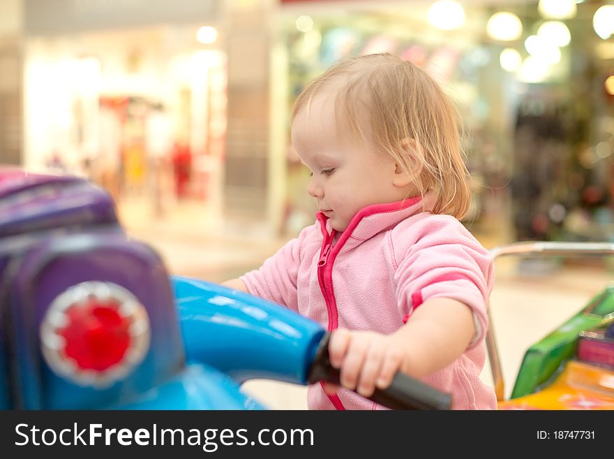 Young adorable baby ride on baby motorcycle in mall