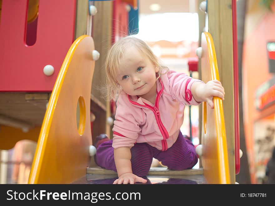Adorable baby prepare to slide down on playground