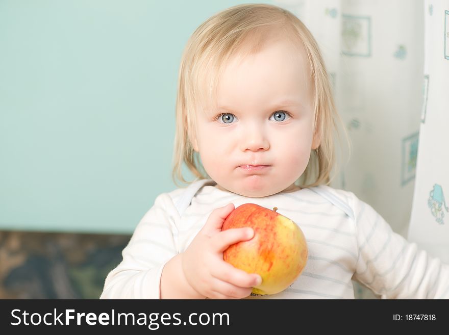 Adorable baby holding red orange apple