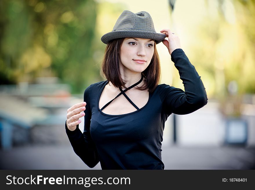 The beautiful girl holds a hat