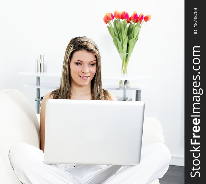 Beautiful blond woman on sofa with computer