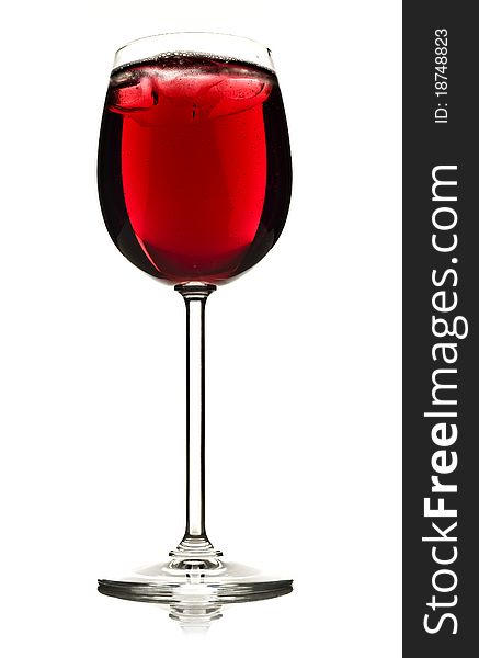 Wine glass with red fruit juice and ice on a white background
