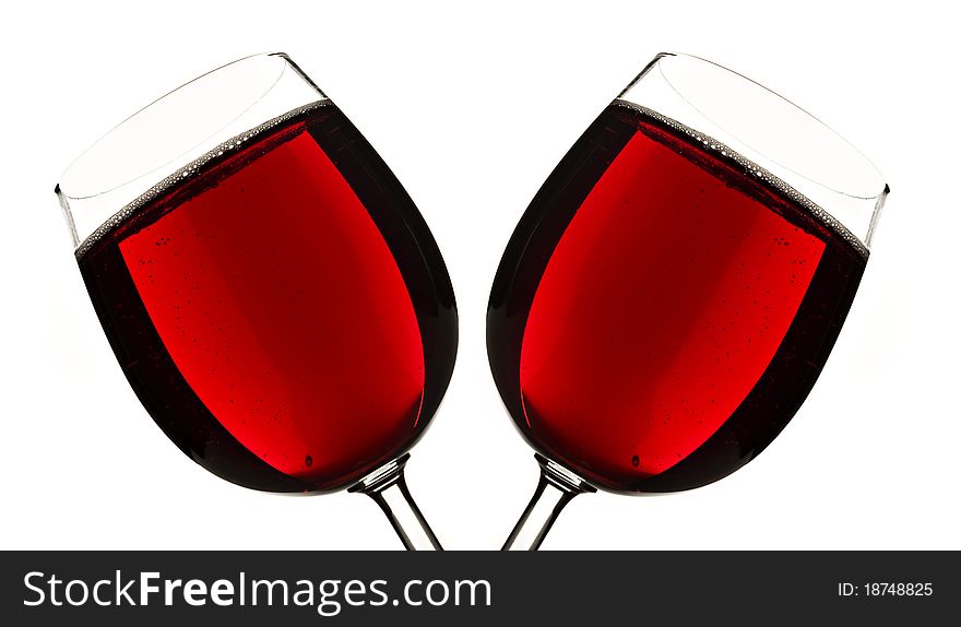 Close up of two glasses of red fruit juice on a white background