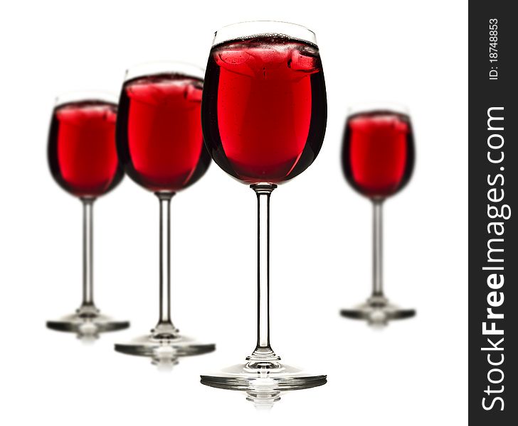 Wine glasses with red fruit juice and ice on a white background