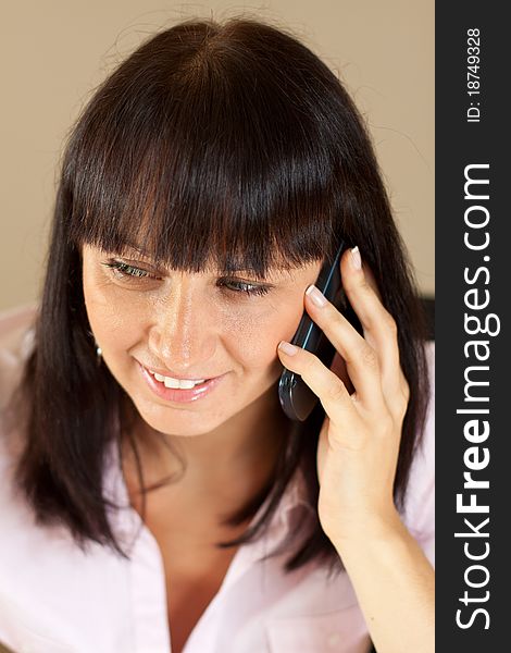 Young businesswoman talking over the phone with bright smile