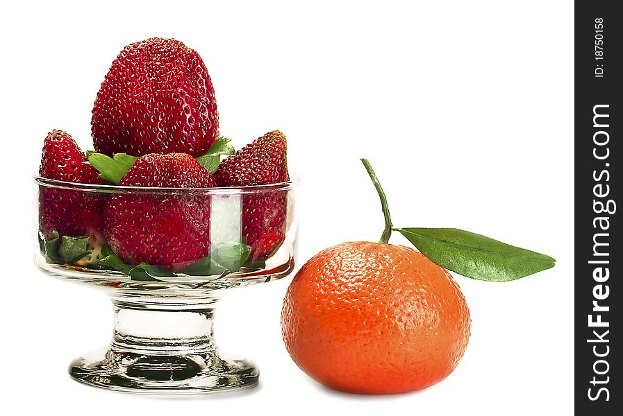 Strawberry in glasswares and a tangerine nearby. Strawberry in glasswares and a tangerine nearby