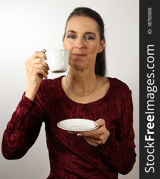 Happy mature woman in red dress with a cup of coffee. Happy mature woman in red dress with a cup of coffee