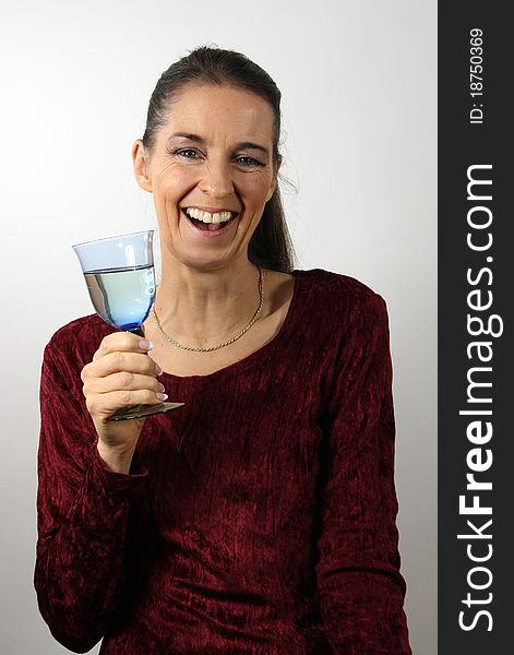 Laughing mature woman in red dress with a glass of white wine. Laughing mature woman in red dress with a glass of white wine