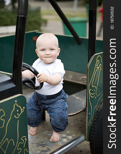 Blond boy driving a toy car