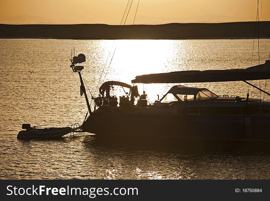 Private sailing yacht silhouetted at sunset whilst at anchor. Private sailing yacht silhouetted at sunset whilst at anchor
