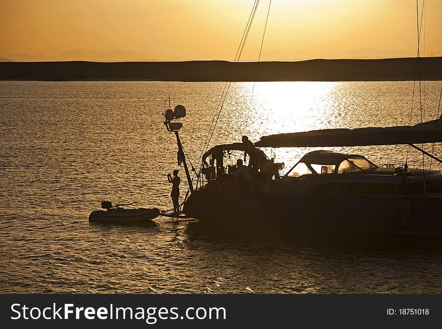 Private sailing yacht silhouetted at sunset whilst at anchor. Private sailing yacht silhouetted at sunset whilst at anchor