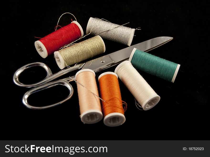 Scissors and yarn of different colors are used for embroidery and sewing. Scissors and yarn of different colors are used for embroidery and sewing