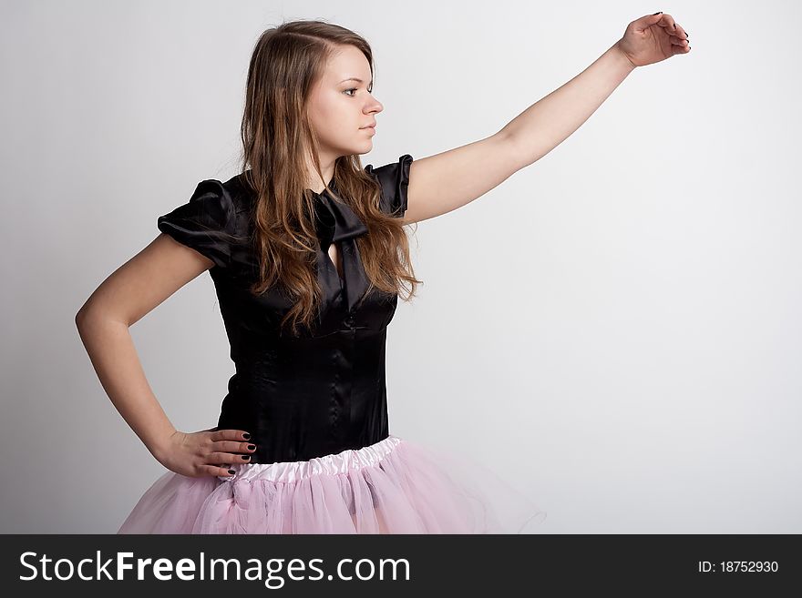 Young girl in a pink skirt on a light background