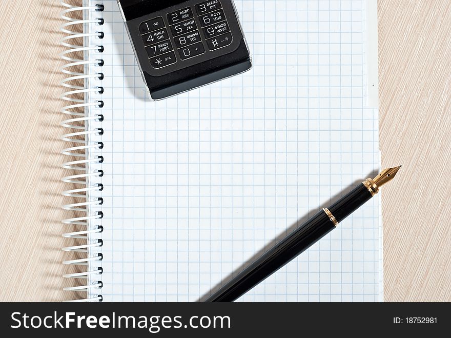 Mobile phone, notepad and pen on wood desk. Mobile phone, notepad and pen on wood desk