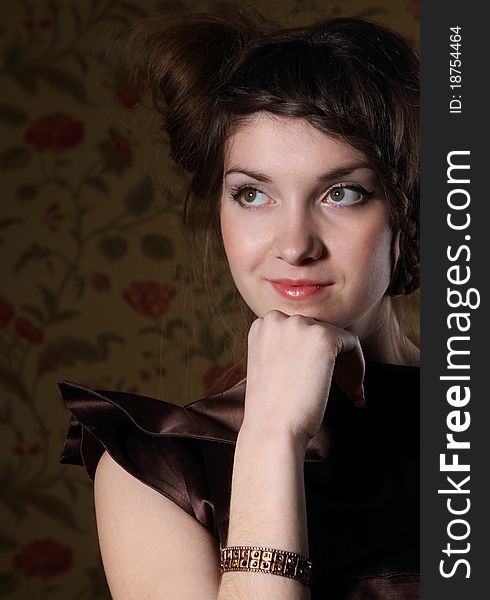 Portrait of the beautiful stylish brunette woman in brown dress