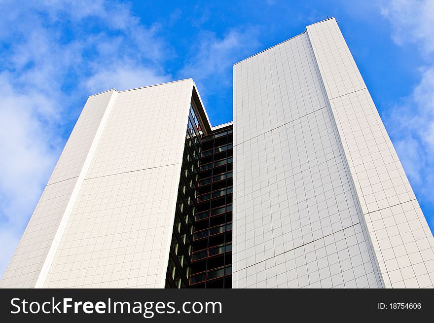 White corporate building with blue cloudy sky in background