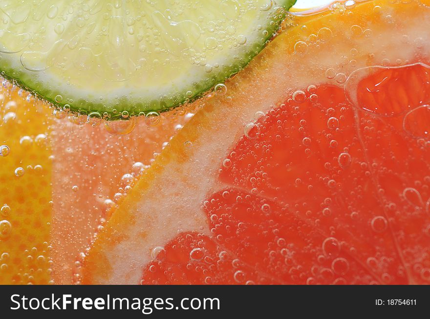 Sliced grapefruit with lime in mineral water. Sliced grapefruit with lime in mineral water