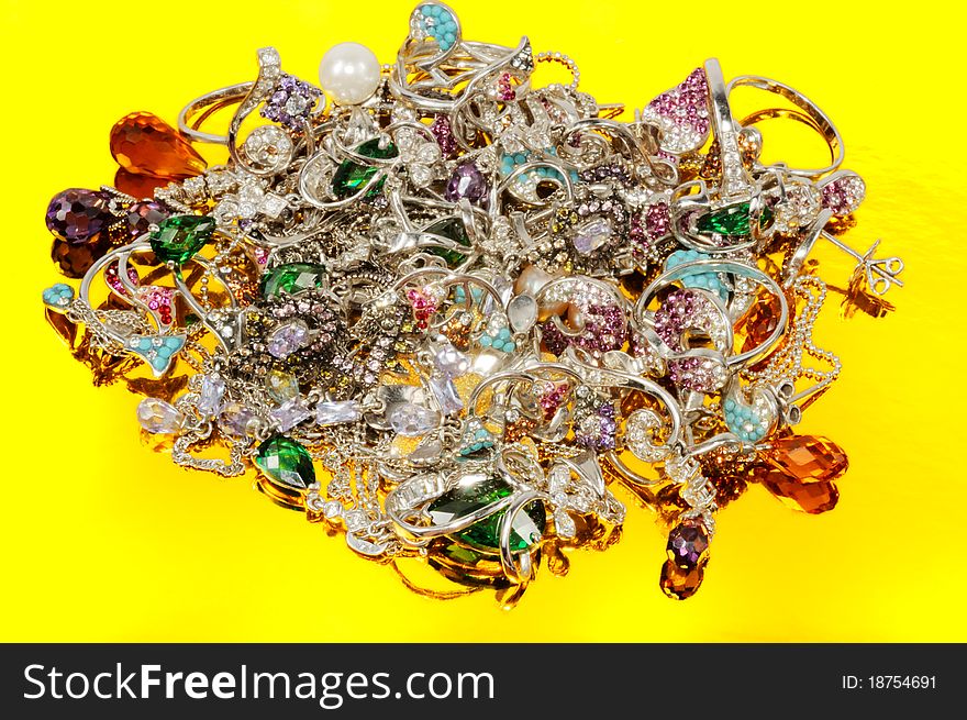 Stack of gold jewelry on a gold background
