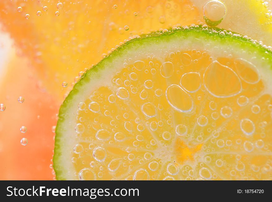 Sliced grapefruit with lime in mineral water. Sliced grapefruit with lime in mineral water