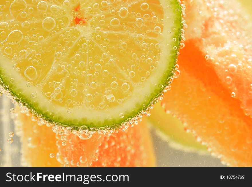 Sliced grapefruit with lime in mineral water. Sliced grapefruit with lime in mineral water