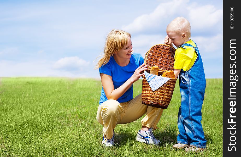 Happy young woman and her son having a picnic outdoor on a summer day. Happy young woman and her son having a picnic outdoor on a summer day