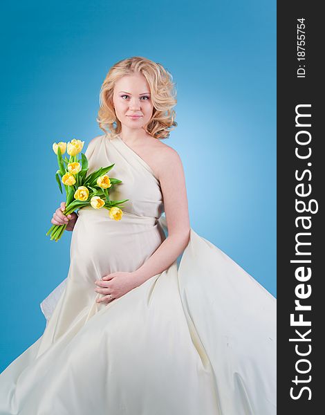 Young beautiful woman with flowing hair holding a bouquet of tulips