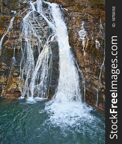 Mountain waterfall on a rock and blue lake