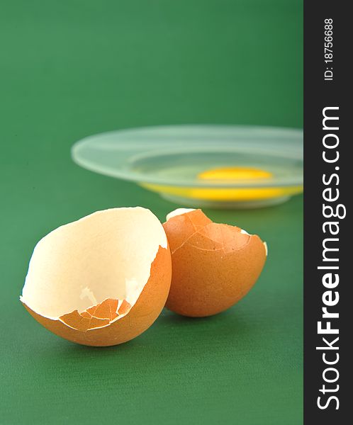 Broken egg isolated on green background