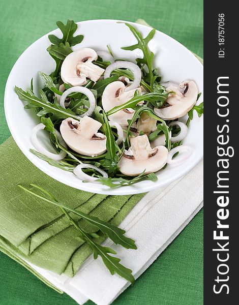 Fresh salad with rucola, mushrooms and onion in bowl