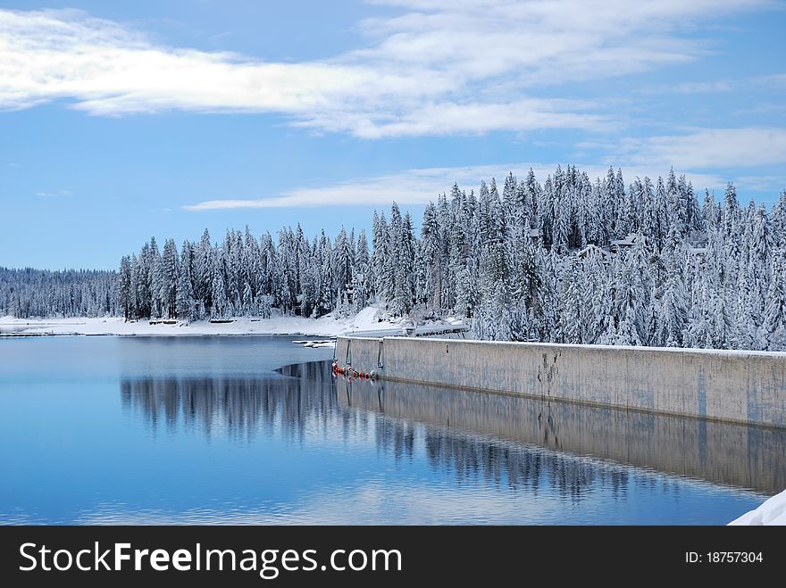 Lake and dam with fresh powder on the surrounding trees. Lake and dam with fresh powder on the surrounding trees