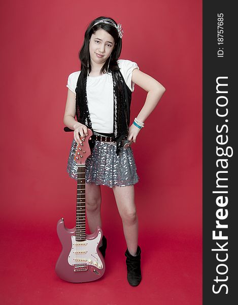 Preteen girl with attitude problem holding pink guitar. Preteen girl with attitude problem holding pink guitar