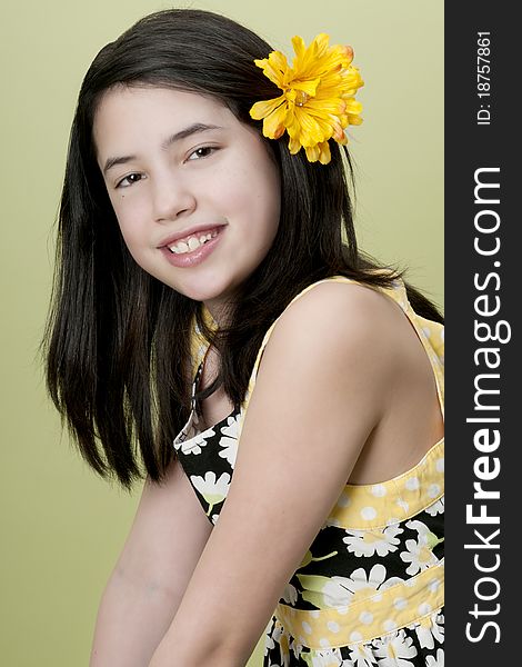 Preteen model posing with yellow flower in hair. Preteen model posing with yellow flower in hair