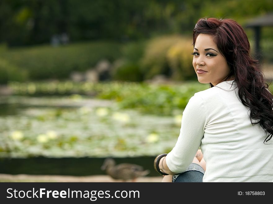 Attractive young woman sitting at the park