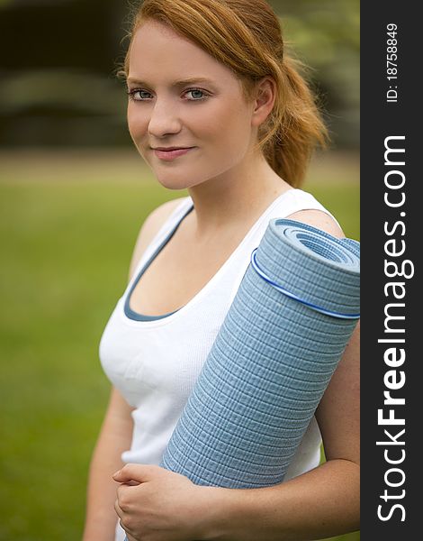 Young woman outside with yoga mat. Young woman outside with yoga mat