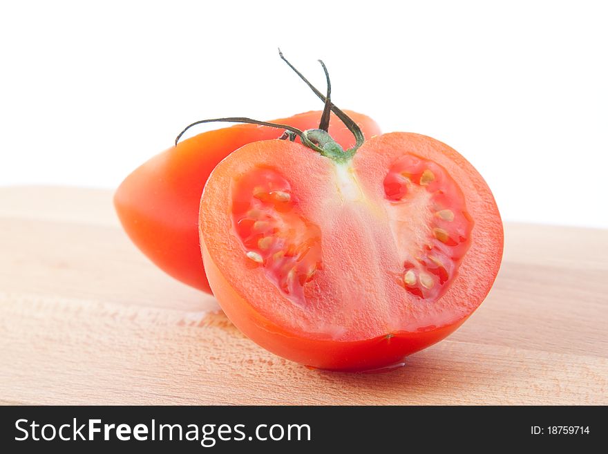 Two part of tomato on brown kitchen board. Horizontal image