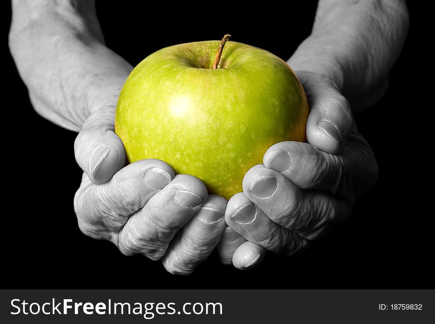 Apple in a hand old woman on the black