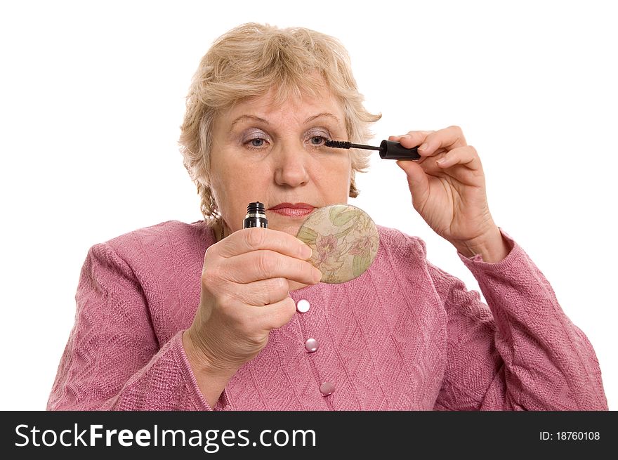 The elderly woman does a make-up on white