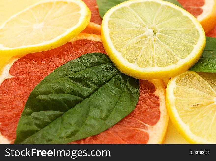 Fresh juicy grapefruits with green leafs close up