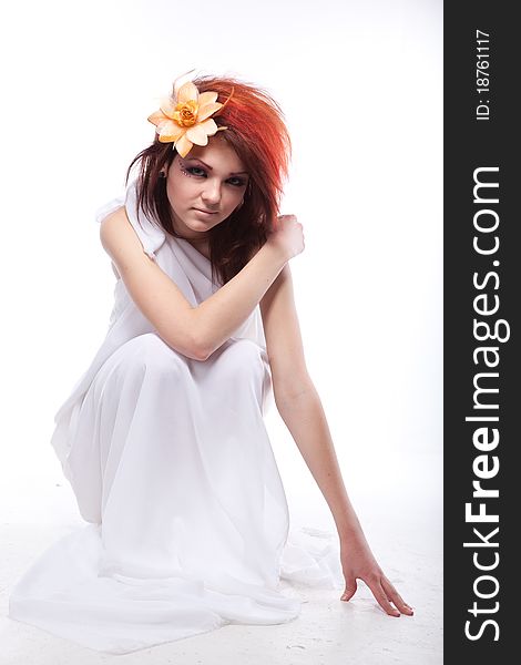 Portrait of beautiful woman with spring flower in hair on white