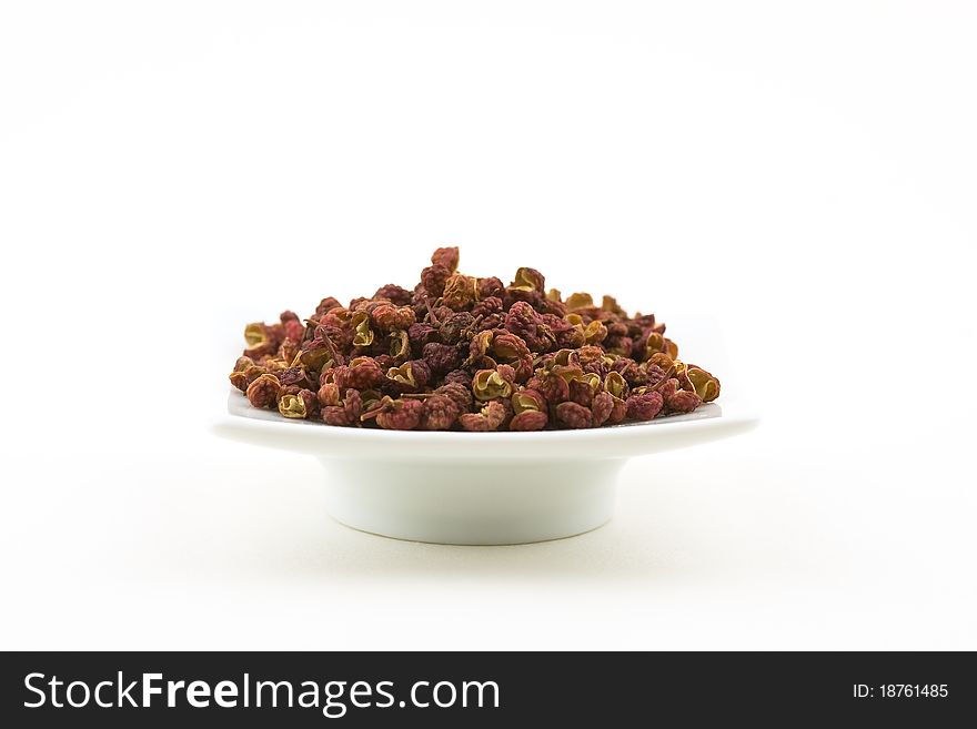 Small bowl of a Szechuan (or Sichuan) pepper, Asian spice isolated on white. Shallow DOF. Small bowl of a Szechuan (or Sichuan) pepper, Asian spice isolated on white. Shallow DOF