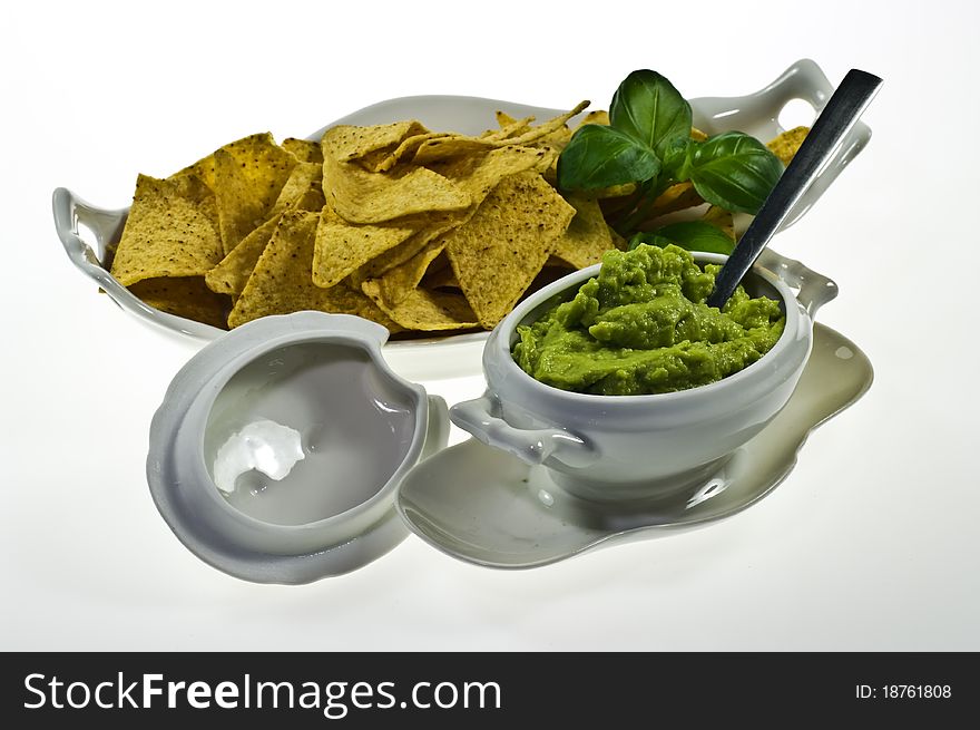 Guacamole in porcelain souce boat and nachos. Guacamole in porcelain souce boat and nachos