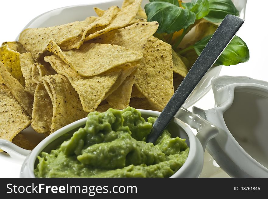 Guacamole in porcelain souce boat and nachos. Guacamole in porcelain souce boat and nachos