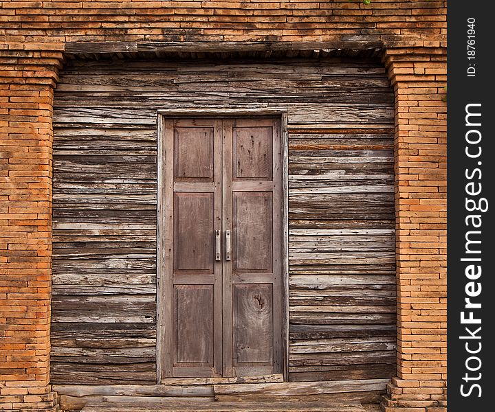 Old solid wood door and wall with bricks line. Old solid wood door and wall with bricks line.