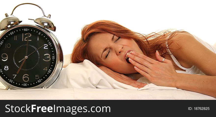 Young woman lying in bed with alarm clock. Young woman lying in bed with alarm clock