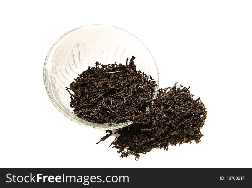 A glass cup of dried black tea on white background