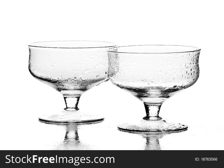 Two wine glasses with drops of water on it. White background. Studio shot. Two wine glasses with drops of water on it. White background. Studio shot.