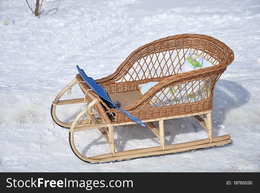 Children's wicker sled stand in the snow